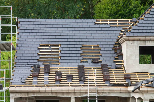 Rénovation d’une couverture, rangs d’ardoises en cours de pose