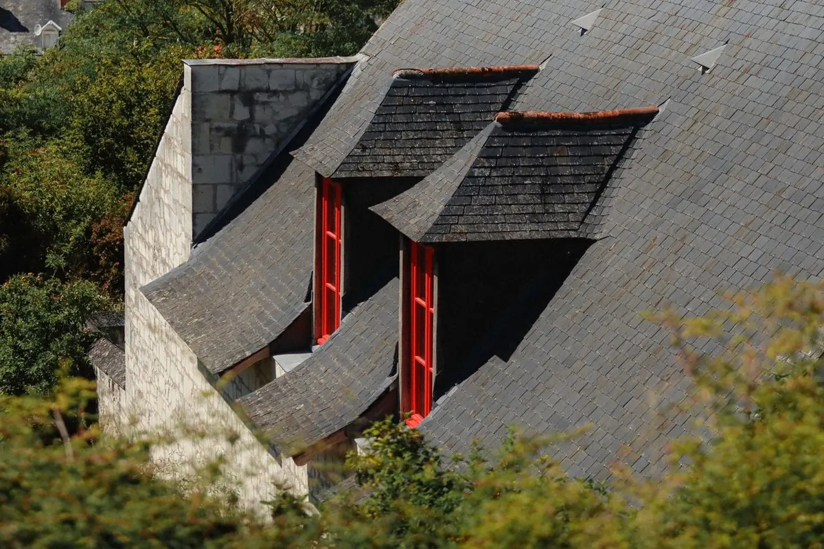 Toiture en ardoise avec lucarnes aux montants rouges, réparation de couverture près de Brest