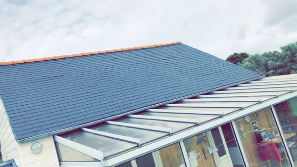 Toiture en ardoise entretenue au-dessus d’une véranda dans le Finistère